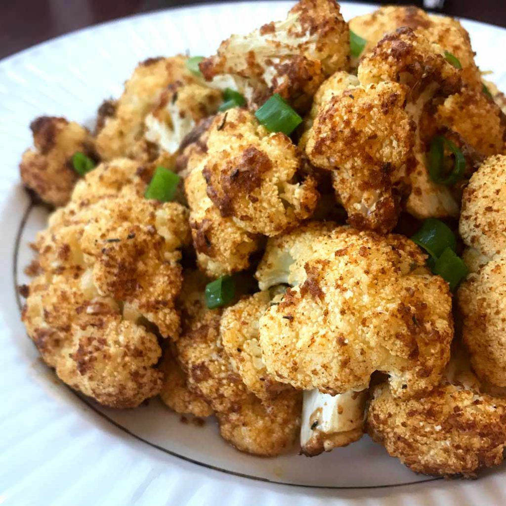 Roasted Cauliflower in a plate, garnish with green onion