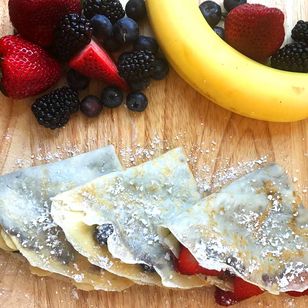 different nutella crepes filling, including strawberry crepe, blueberry crepe. banana crepe, with some fresh fruits and berries