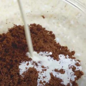adding heavy cream into chocolate cake crumbs